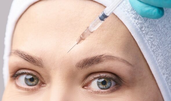 Dermatologist Performing Dermal Filler Treatment On Patient's Forehead